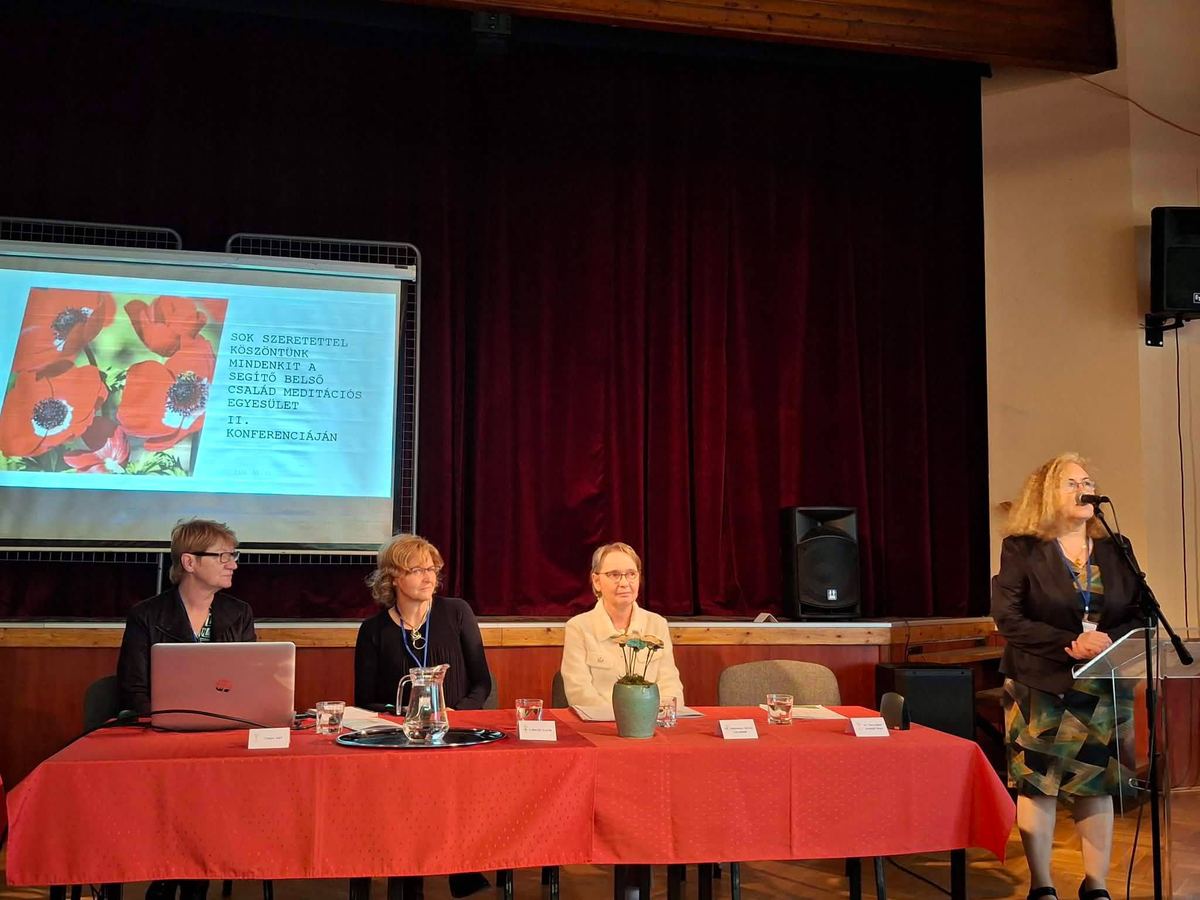 A konferencia megnyitója: az elnökség a színpadon, a vetítővásznon köszöntő dia.